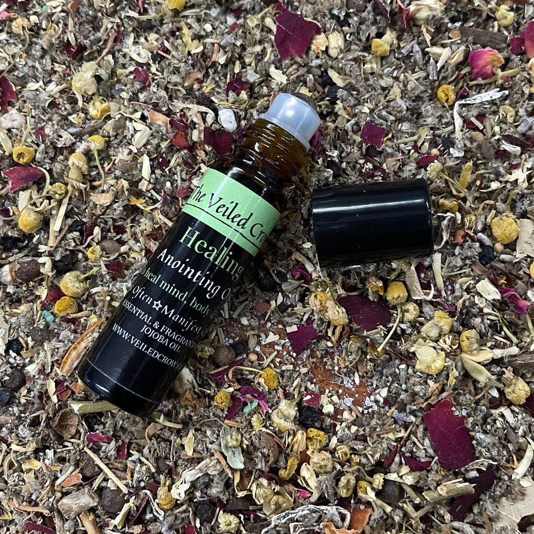 Small bottle of essential oil on a bed of dried herbs and flowers