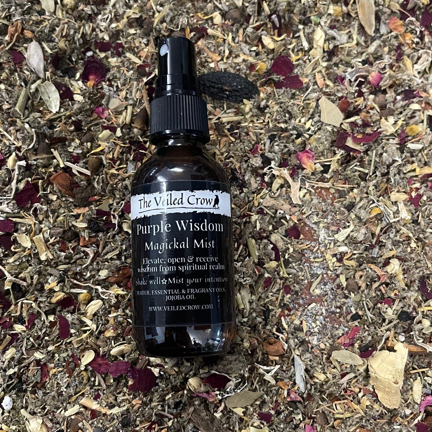 Purple Wisdom Mist on a bed of dried herbs and flowers.